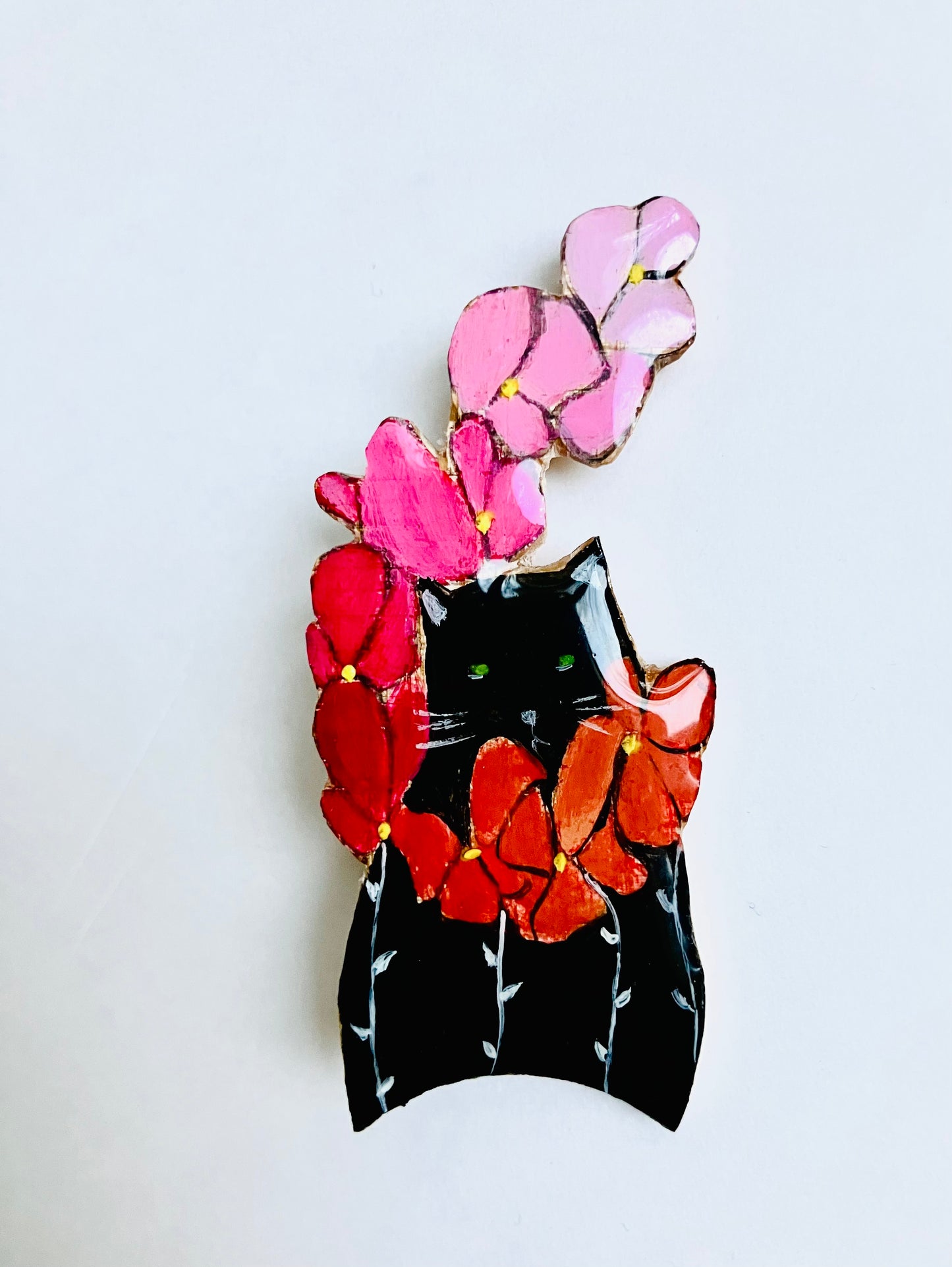 Chat noir à la branche de fleurs