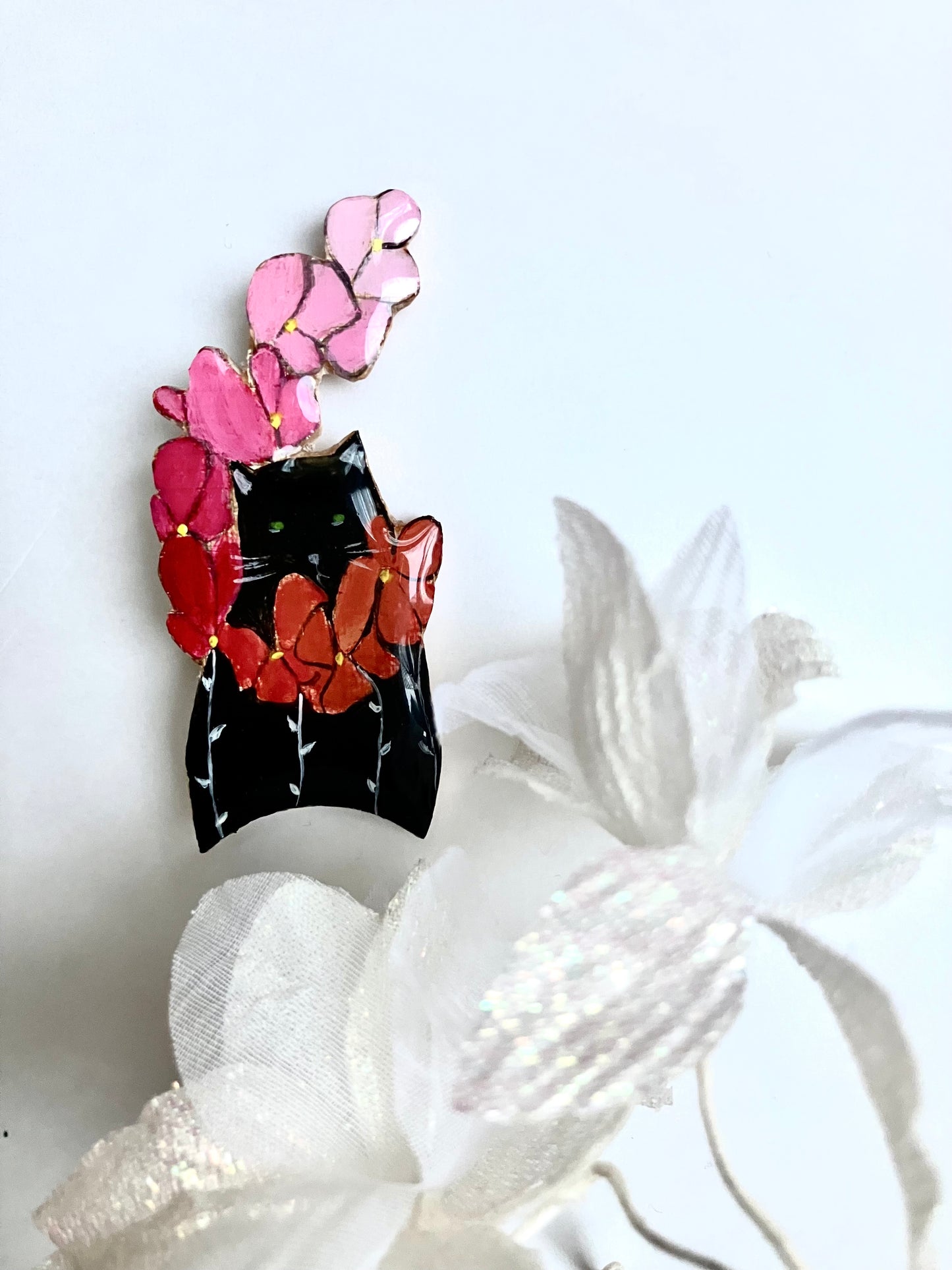 Chat noir à la branche de fleurs